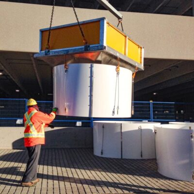 Worker and crane assemble a Superchute snow chute.